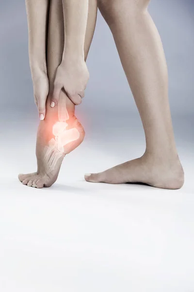 The ankle is always a painful injury. a woman holding her inflamed foot