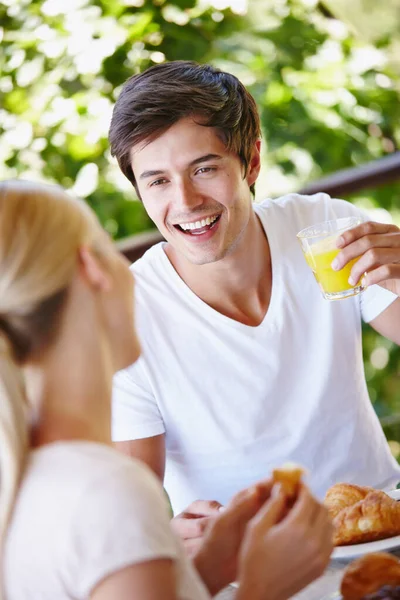 朝食を持ってきて 幸せな若いカップルが家のパティオで一緒に朝食を食べます — ストック写真