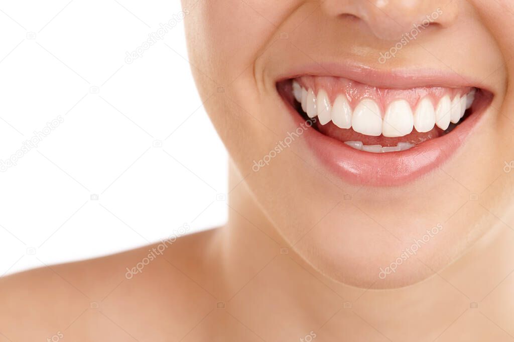 Perfectly white. Closeup shot of a young womans toothy smile against a white background
