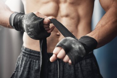 Training, fitness and boxing man prepare for workout or match at gym or fitness center with hand wrap. Closeup of athletic boxer getting ready for strength, cardio and endurance kickboxing challenge. clipart