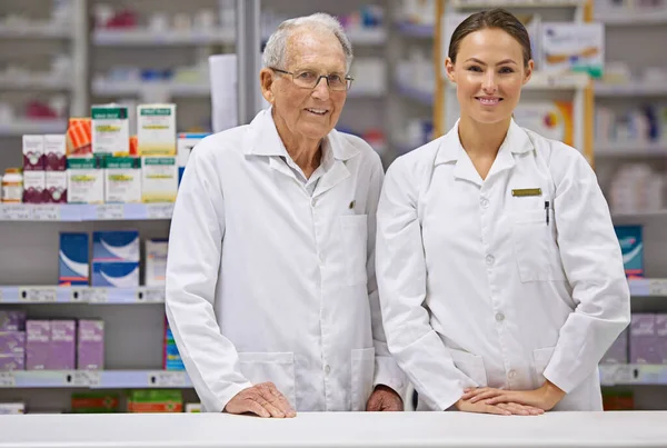 Years Pharmaceutical Experience Elderly Pharmacist Young Pharmacist Standing Counter — Stock Photo, Image
