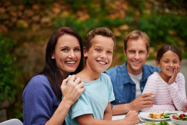 食物和家庭时刻 一个微笑的家庭在庭院里享用晚餐的画像 — 图库照片