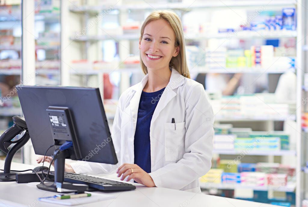 How may I help today. Portrait of an attractive pharmacist using a computer