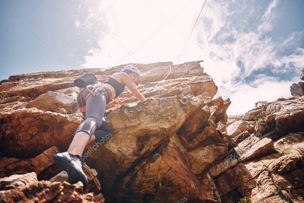 Fitness, extreme sports and rock climbing woman on a mountain, enjoy a climb in nature and freedom. Athlete, adrenaline and energy with female on adventure, physical challenge exercise cliff hanging.