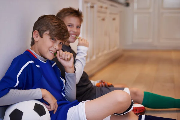 男孩将是男孩 两个小男孩坐在一起 拿着足球 吃着零食 — 图库照片