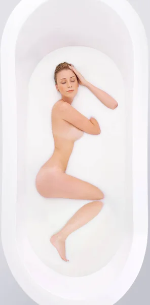 Güzellik Banyosu Sütlü Bir Sıvıya Batırılmış Bir Kadının Stüdyo Fotoğrafı — Stok fotoğraf