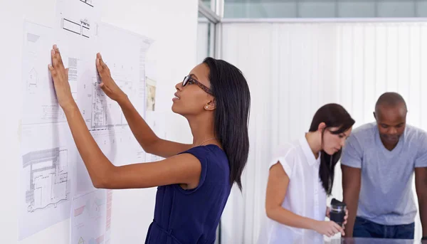 組織化されてる 建築計画を検討している若い女性建築家で同僚が仕事をしながら — ストック写真