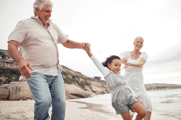 老年人家庭 带着孩子在海滩为爱 支持和孩子的发展或户外的健康 兴奋的祖父母或教女孩跳跃的人 带着健康的精力走在海水边 — 图库照片