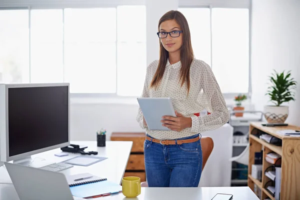 成功就是把平常的事做得特别好 一位年轻女子站在办公桌前拿着数码平板电脑的画像 — 图库照片