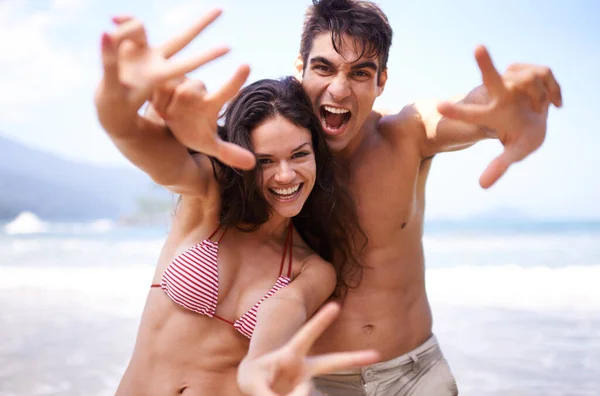 私たちのお気に入りの休日の目的地から叫びを送る ビーチでの休暇を楽しんでいる若いカップルは — ストック写真