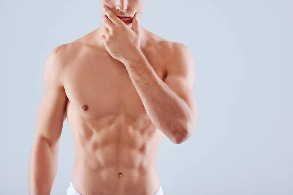Now thats smooth. Cropped studio shot of a handsome bare chested young man with his waist wrapped in a towel