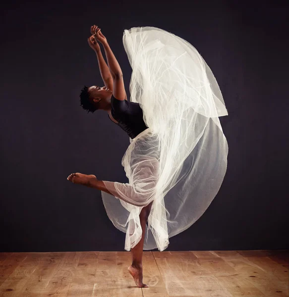 Flying free. Young female contemporary dancer using a soft white white skirt for dramatic effect