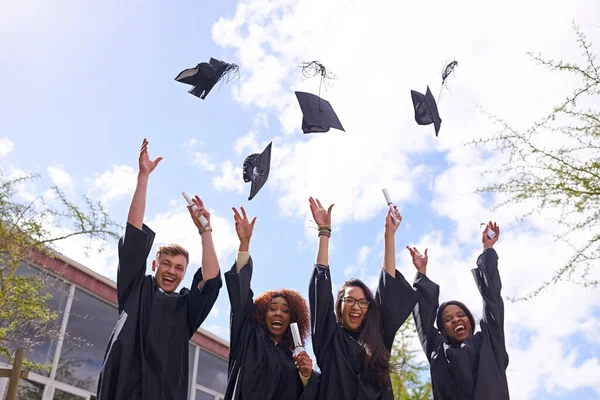 お祝いの理由 卒業帽子を空中に投げ込む学生の低角度ショット — ストック写真