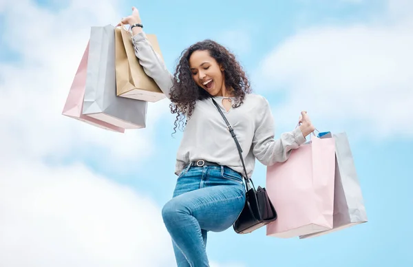 City shopping, retail sale and woman with fashion deal, excited about luxury discount and happy about designer market on blue sky in Paris. Rich, wealth and young girl with bag and smile in summer.