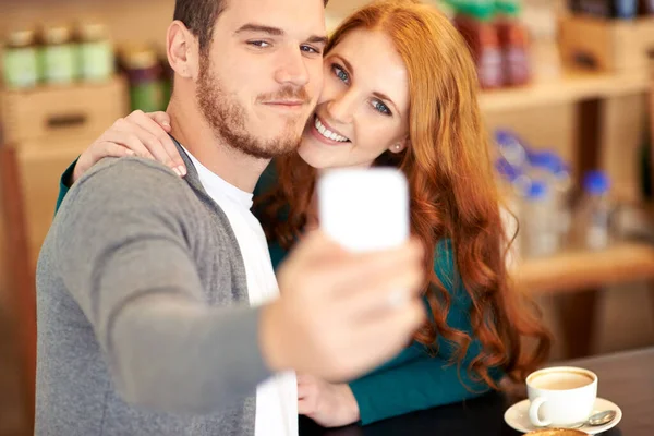 彼の熱いデートを披露 若いカップルがカフェでデート中に写真を撮り — ストック写真