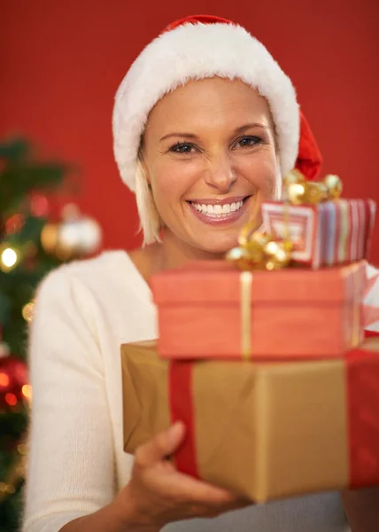 プレゼントを積み上げて 幸せな若い女性がクリスマスプレゼントを持っていて — ストック写真