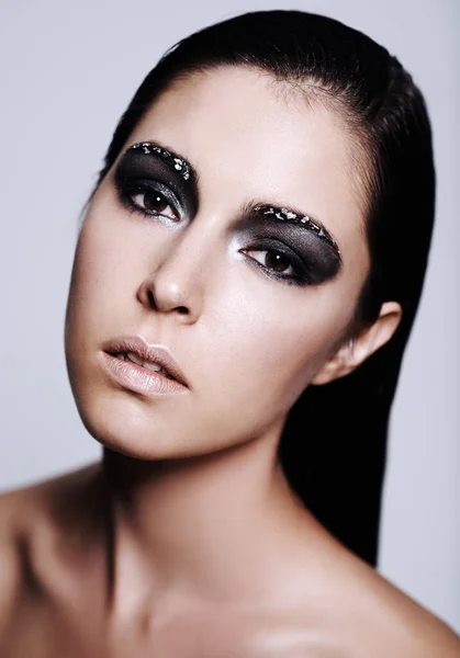 Her beauty shimmers and shines like metal. Studio portrait of a beautiful young woman wearing metallic-colored makeup