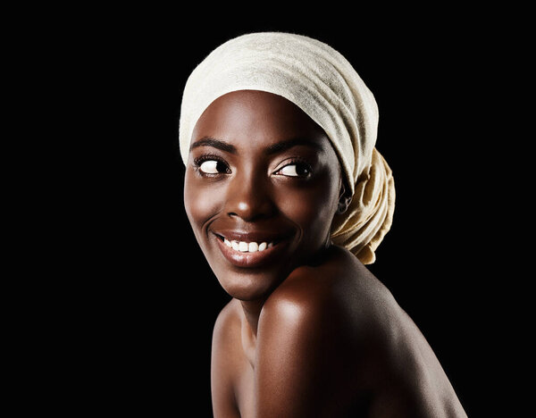 Beautiful skin. Studio portrait of a beautiful woman wearing a headscarf against a black background