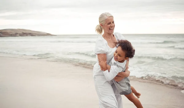 ビーチ 楽しいと祖母は休日のために子供と遊ぶ 結合し 海で一緒に世話をします 夏休みと海に抱かれた幼女とおばあちゃんとの幸せな関係 — ストック写真