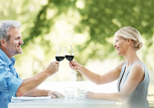 私たちの継続的な幸福と愛にここに 幸せな成熟したカップルToasting彼らの愛とともに2杯のワイン屋外 — ストック写真