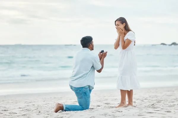 해변에서의 파트너 그리고 모래에 낭만적 남자가 무릎을 결혼반지를 꺼내는걸보고 충격을 — 스톡 사진