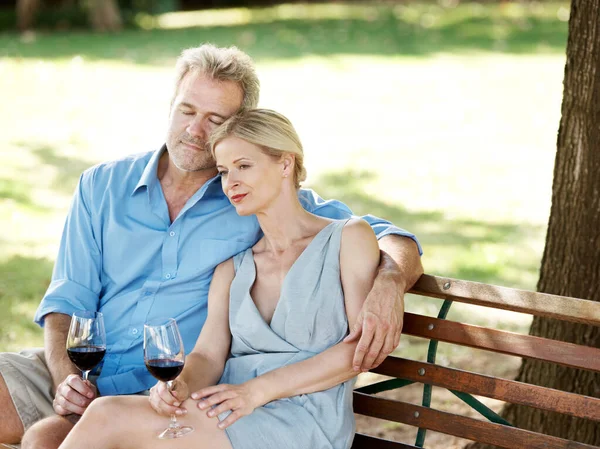 彼らの生活を一緒に反映 大人のカップルが公園で屋外で一緒にワインを飲むのが大好き — ストック写真