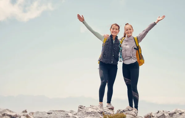 Travel, hiking and success with women on mountain cliff, trekking and adventure trip together. Freedom, landscape and rock climbing with friends explore on backpack journey and standing on hill top.