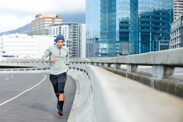 Racing through the city. a young man jogging through empty city streets