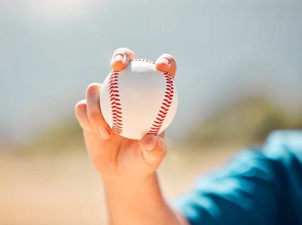 Fitness, sports and baseball training by a child practice his pitcher skills at an outdoor baseball field. Exercise, motivation and power with young boy closeup hand holding a ball, ready to pitch.