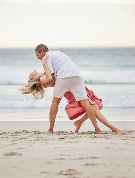 Dancing, happy couple and beach celebrate of love, trust and engagement on romantic luxury holiday travel Bali vacation. Man and woman or dancer couple celebration on sea water, sand and sunset ocean.