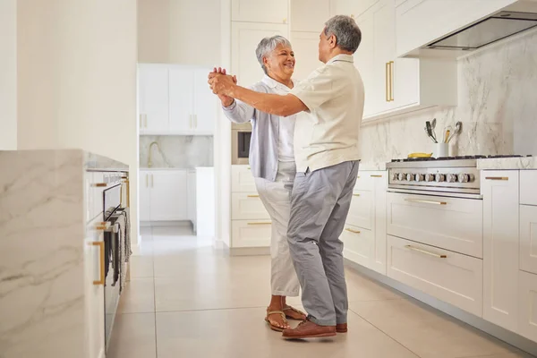 Senior couple dance, kitchen and elderly love of people spending quality time together at home. Happy retirement of a woman and man from Mexico dancing in their house with a smile and happiness.