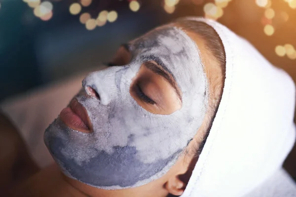 Divine skin pampering. A young woman relaxing during a facial treatment at a spa