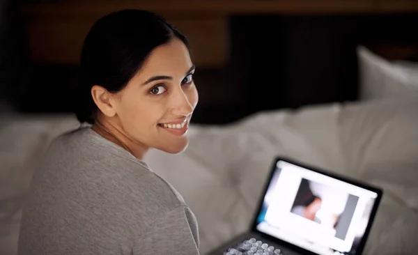 友人とオンラインで交流する ベッドでノートパソコンで働いてる若い女性が — ストック写真