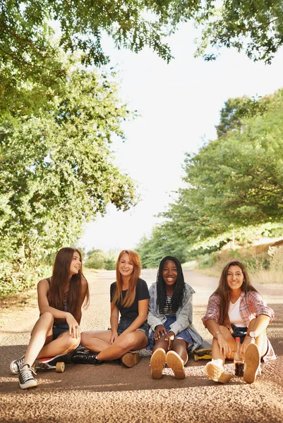 笑いはすぐに休暇です 屋外で互いの会社を楽しんで座っている多人種の十代の若者のグループ — ストック写真