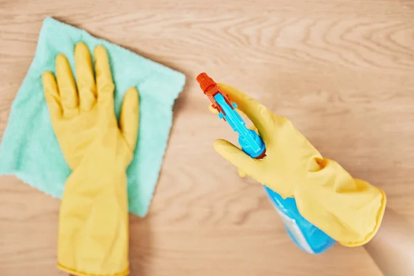 Cleaning spray, glove hands and wipe table, counter and wood surface for housekeeping service at home. Above of maid, janitor and cleaner dust cloth chore, furniture shine and chemical bottle product.