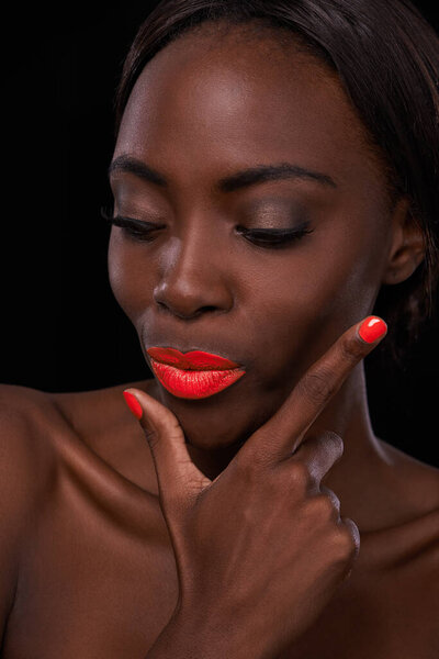 Pouting pretty. an attractive african woman with bright red lips and nail polish