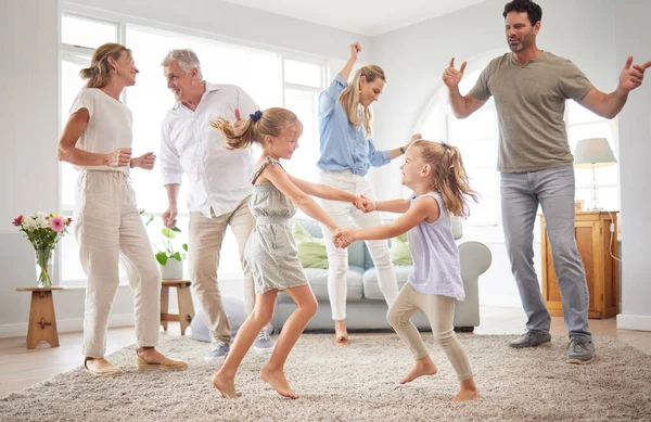 Happy, dance and love with big family in living room together for crazy, energy and excited. Lifestyle, freedom and celebration dancing at modern home with parents, children and grandparents.