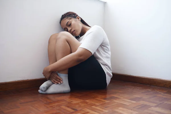 焦虑和孤独的女人坐在一个角落 患有精神健康问题 处于压力 抑郁或虐待中的黑人女性独自躺在公寓 家或房间的木制地板上 — 图库照片