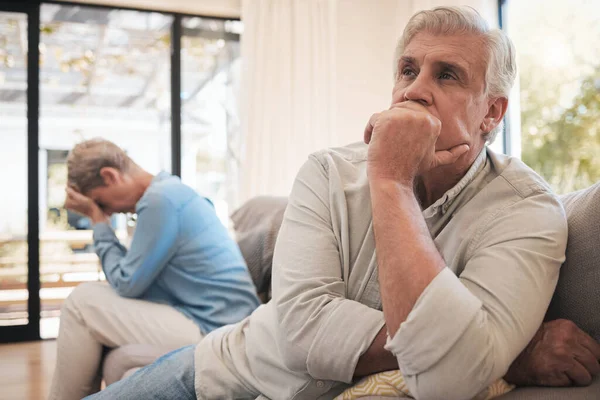 悲しいニュースや自宅のリビングルームで戦う後 高齢者のカップルのストレス 失意の表情でソファの上で引退した女性とシニア男 家の中で怒っているか落ち込んで — ストック写真