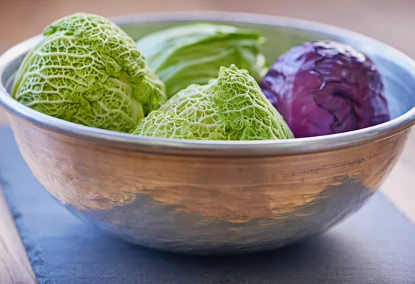 Bowl of delicious produce. a purple and green cabbage in a bowl