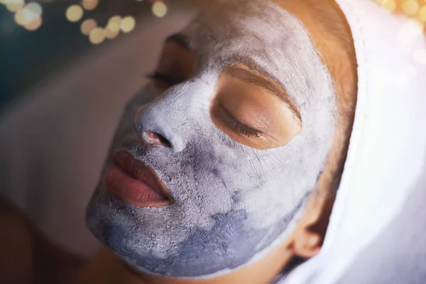 On her way to dream skin. A young woman relaxing during a facial treatment at a spa
