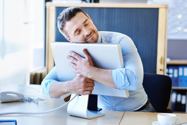 Its a businessmans best friend. a businessman hugging his monitor warmly