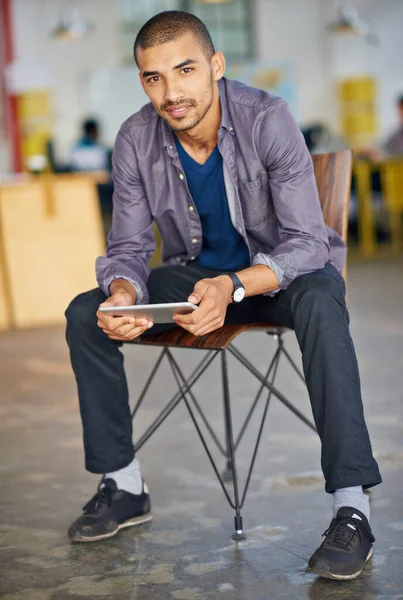 Made with mobility in mind. Portrait of a handsome young man using a digital tablet in an office