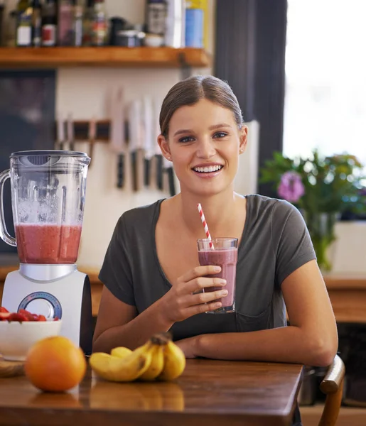 Savoring her fresh smoothie. Portrait of an attractive young woman enjoying a fruit smoothie she made