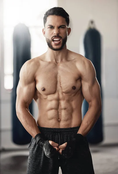 Fitness, sport and man boxer with motivation, vision or exercise goals, health and wellness in gym. Powerful flexing of healthy sports personal trainer with workout for muscle training body in studio.