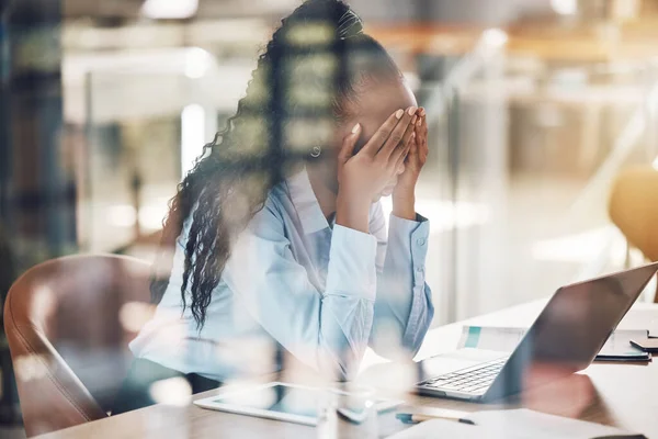 Stress, anxiety and burnout with a business woman suffering with mental health in her office at work. Headache, fatigue and overtime with a stressed female employee at work on a laptop at her desk.