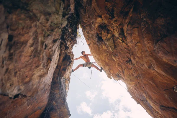 Mountain or rock climbing, cliff hanging and adrenaline junkie with courage on adventure trying to balance between gap. Athletic climber man doing fitness, exercise and workout during extreme sport.