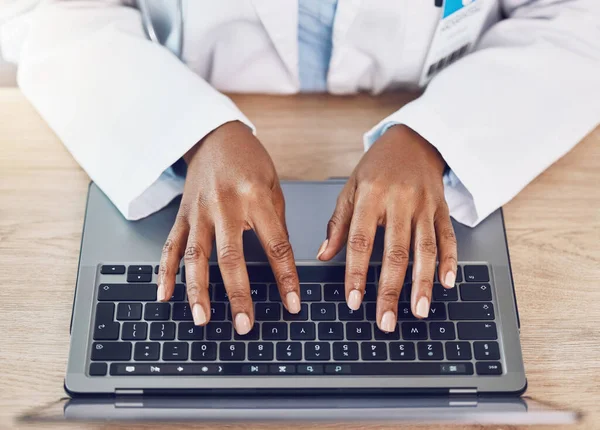 Hands, woman and doctor with laptop working at a desk in a hospital office. Medical expert with wireless technology to diagnose or research diseases in the field of health and medicine online or web.