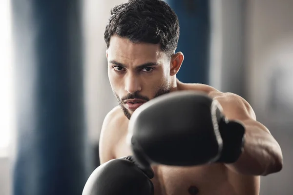 Boxing fitness, motivation portrait and man at the gym for wellness, health workout and sports exercise. Face of a strong boxer athlete with fist power during cardio fight and competition training.