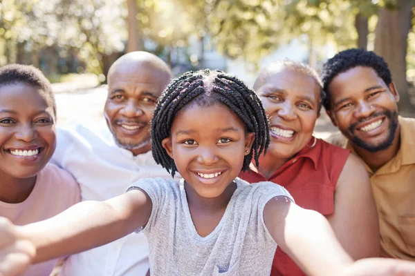 Black family, selfie and smile of child taking a picture with her parents and grandparents outside at a park in nature. Portrait of a girl having fun, love and bonding with family feeling happy.